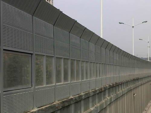 A composite sound barrier along a bridge.